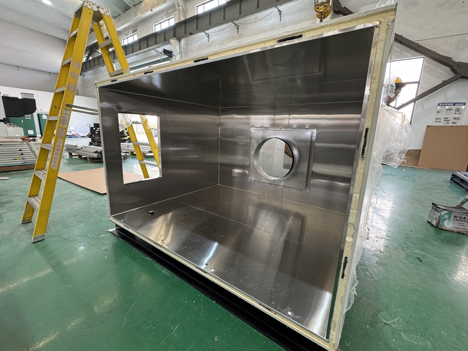 Custom stainless-faced insulated enclosure with circular and rectangular openings in our workshop