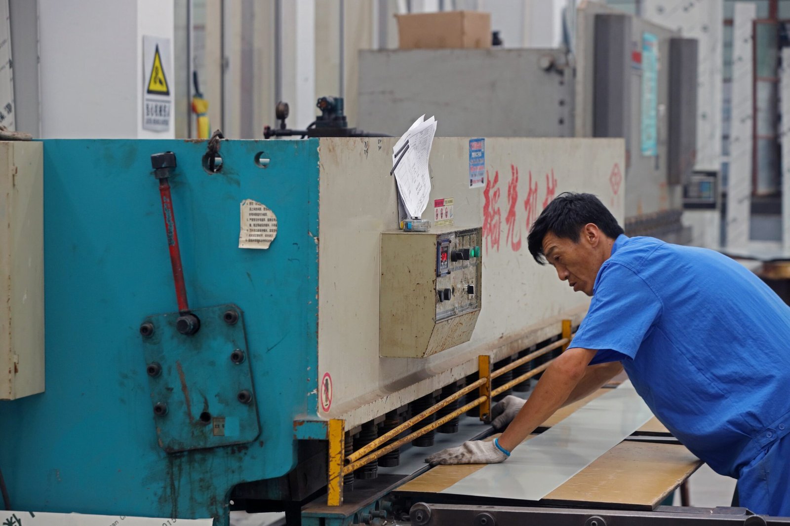 Factory worker processing metal facing material